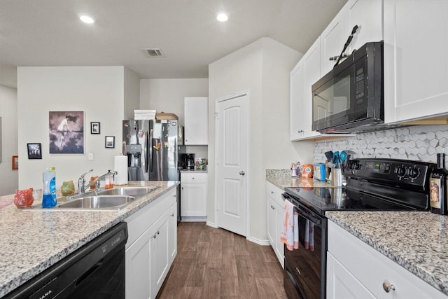 kitchen featuring sink, dark hardwood / wood-style floors, light stone counters, black appliances, and white cabinets