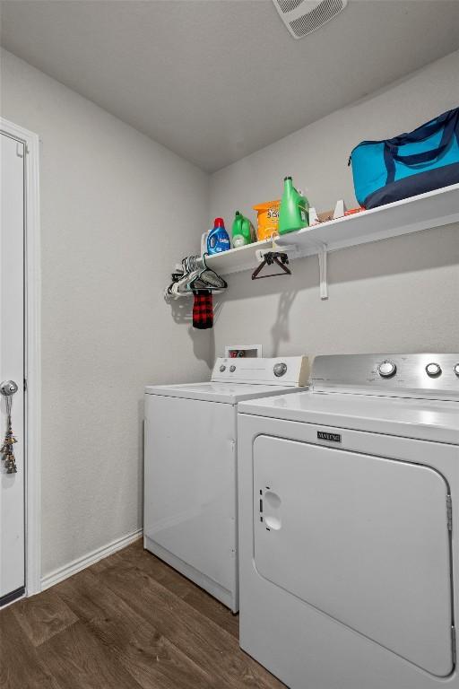 laundry area with independent washer and dryer and dark hardwood / wood-style flooring