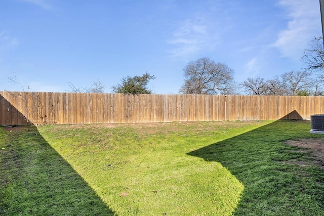 view of yard with central AC and fence