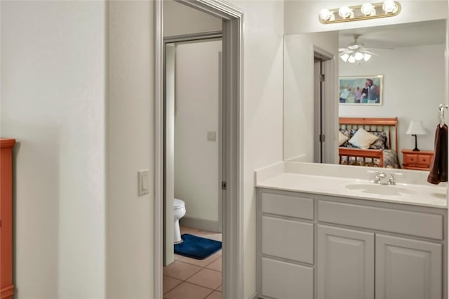 bathroom with tile patterned flooring, vanity, ceiling fan, and toilet