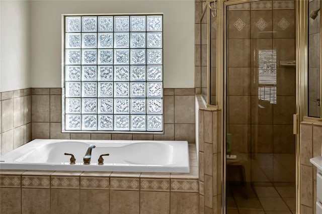 bathroom featuring tile walls and plus walk in shower