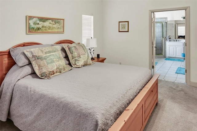 bedroom featuring light colored carpet and ensuite bathroom