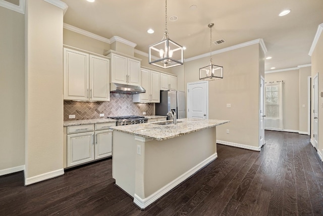 kitchen featuring hanging light fixtures, light stone countertops, sink, and a center island with sink