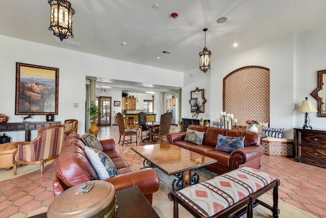 living room featuring a notable chandelier and ornate columns