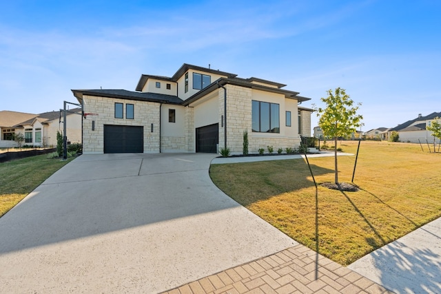 view of front of house featuring a garage and a front lawn