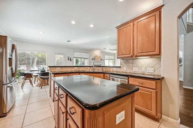 kitchen with sink, appliances with stainless steel finishes, backsplash, a center island, and kitchen peninsula