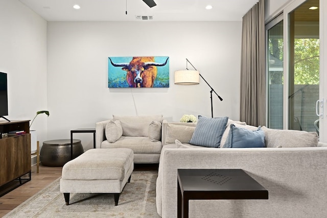 living room featuring hardwood / wood-style flooring and ceiling fan