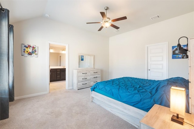 bedroom featuring vaulted ceiling, connected bathroom, light carpet, and ceiling fan