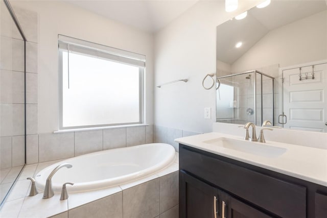 bathroom with vanity, vaulted ceiling, and plus walk in shower