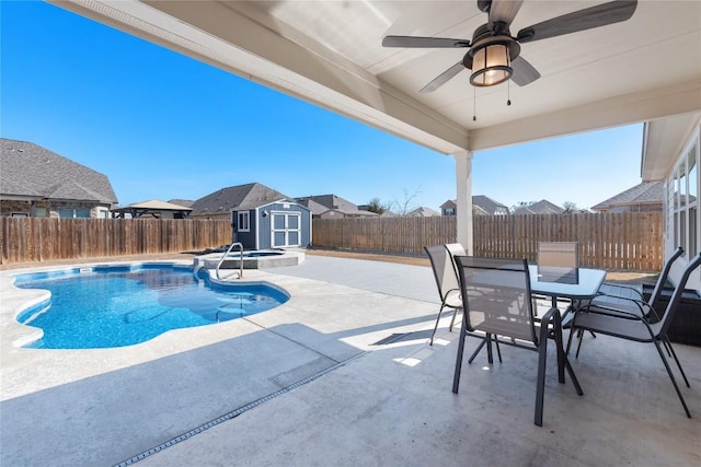 view of pool with an in ground hot tub, a shed, ceiling fan, and a patio area