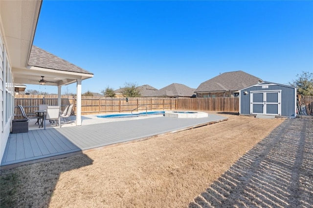 view of pool with ceiling fan, a deck, and a shed