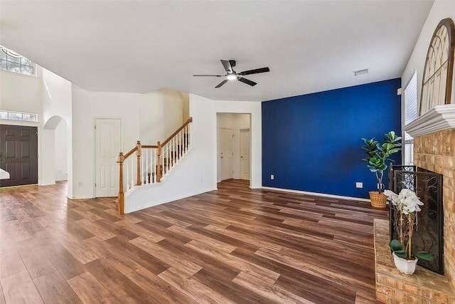 unfurnished living room with ceiling fan, a fireplace, and dark hardwood / wood-style floors