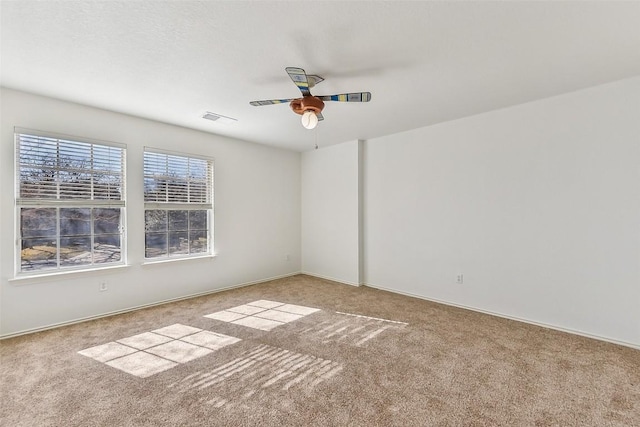 unfurnished room with carpet floors, visible vents, baseboards, and ceiling fan