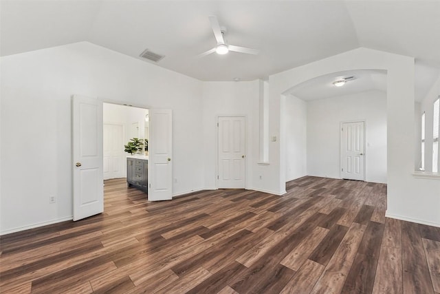 interior space featuring arched walkways, visible vents, lofted ceiling, ceiling fan, and dark wood-type flooring