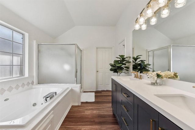 bathroom featuring wood-type flooring, lofted ceiling, shower with separate bathtub, and vanity