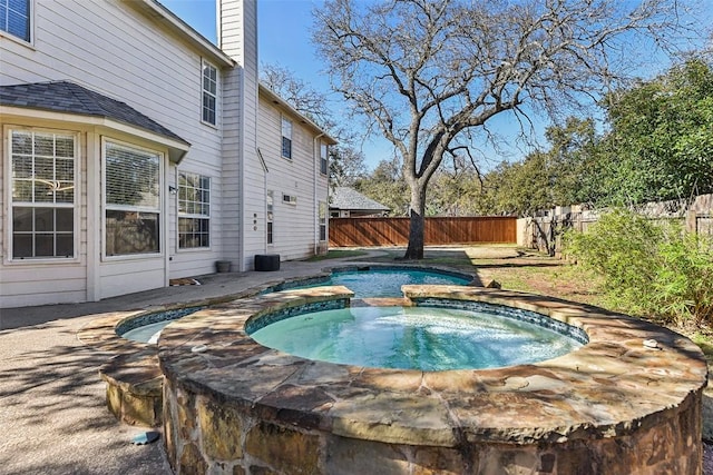 view of pool with a fenced backyard, a fenced in pool, and an in ground hot tub