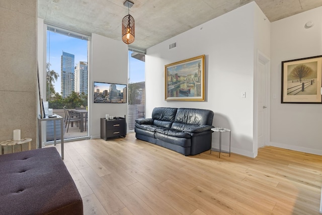 360 Nueces St Unit 914, Austin, TX 78701 - living room with light wood-style floors, baseboards, and a wall of windows