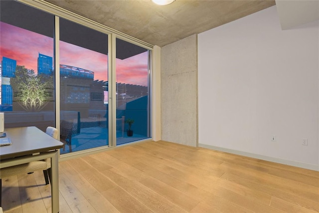 360 Nueces St Unit 914, Austin, TX 78701 - spare room with wood finished floors, a wall of windows, a view of city, and plenty of natural light