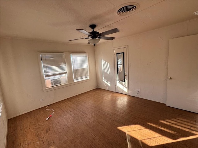 unfurnished room with cooling unit, wood-type flooring, and ceiling fan