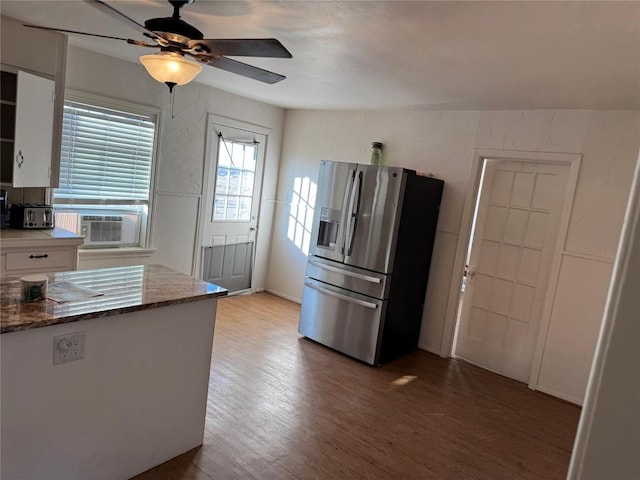 kitchen featuring white cabinetry, wood-type flooring, dark stone counters, ceiling fan, and stainless steel refrigerator with ice dispenser