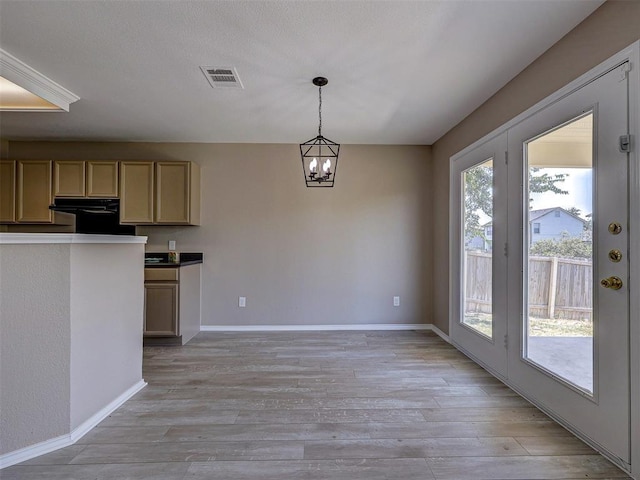 kitchen featuring hanging light fixtures, a chandelier, light brown cabinetry, and light wood-type flooring