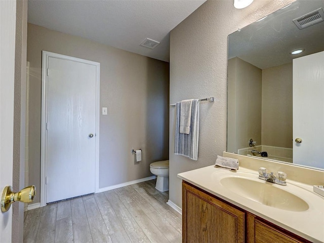 bathroom featuring vanity, hardwood / wood-style floors, and toilet