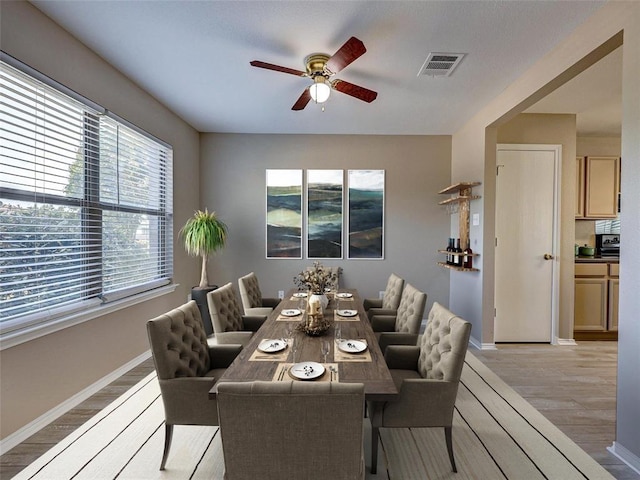 dining area with ceiling fan and light hardwood / wood-style flooring