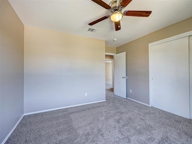 unfurnished bedroom featuring carpet, ceiling fan, and a closet