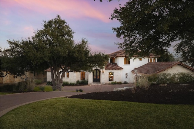 mediterranean / spanish-style home with a lawn