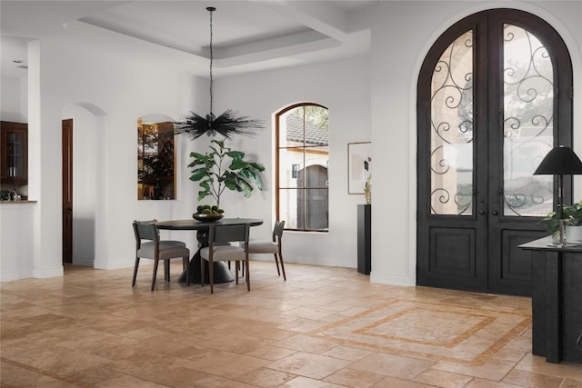 entrance foyer with french doors and a raised ceiling