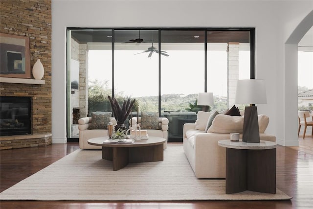 living room with hardwood / wood-style flooring, ceiling fan, and a fireplace