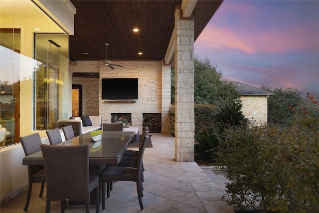 view of patio / terrace with ceiling fan and an outdoor stone fireplace