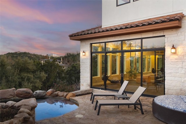 pool at dusk with a patio