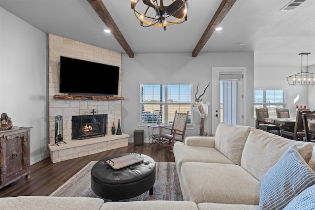 living room with a stone fireplace, dark hardwood / wood-style floors, a notable chandelier, and beam ceiling