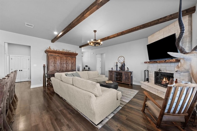 living room featuring dark hardwood / wood-style flooring, a notable chandelier, a stone fireplace, and beam ceiling