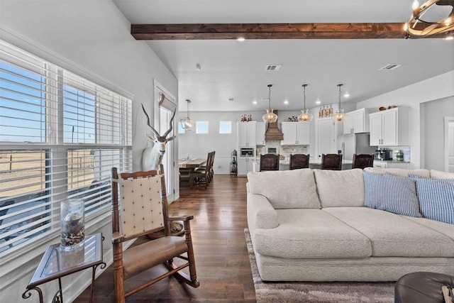 living room with beamed ceiling and dark wood-type flooring