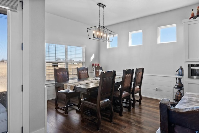 dining area featuring dark wood-type flooring and a chandelier