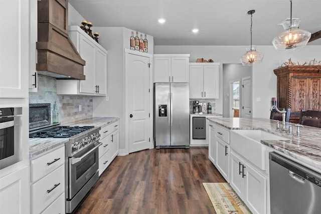 kitchen featuring sink, custom exhaust hood, light stone counters, stainless steel appliances, and white cabinets