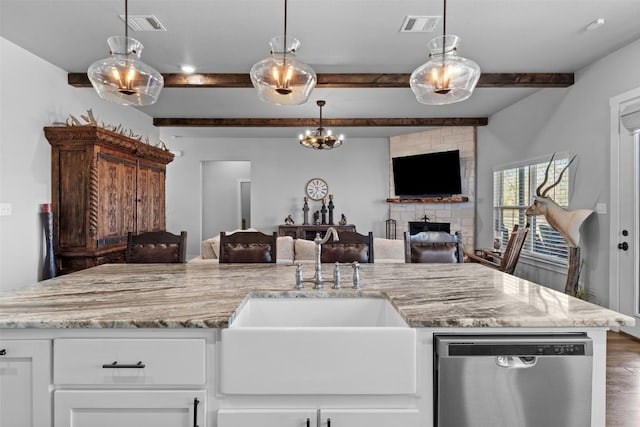 kitchen featuring white cabinetry, dishwasher, sink, hanging light fixtures, and light stone counters