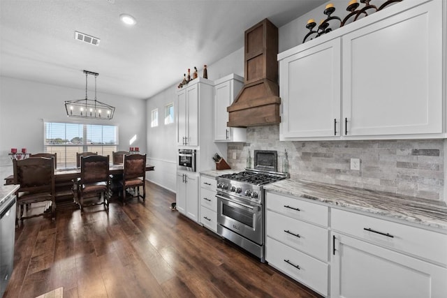 kitchen with pendant lighting, white cabinetry, high end stainless steel range oven, custom exhaust hood, and light stone countertops