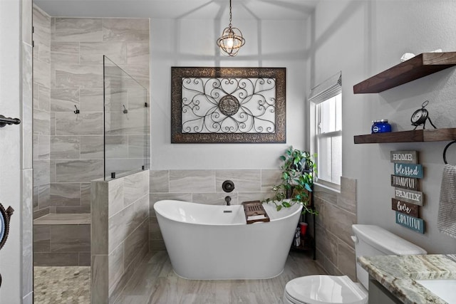 full bathroom featuring tile walls, vanity, shower with separate bathtub, and toilet