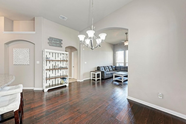 dining area with dark wood-type flooring, high vaulted ceiling, and ceiling fan with notable chandelier