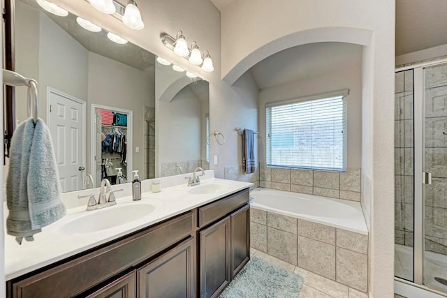 bathroom featuring tile patterned floors, vanity, and shower with separate bathtub