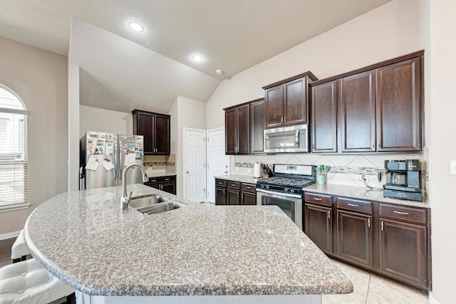 kitchen featuring sink, backsplash, a large island with sink, and appliances with stainless steel finishes