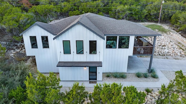 modern farmhouse style home featuring roof with shingles and board and batten siding