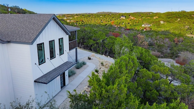 view of home's exterior with a balcony and a shingled roof