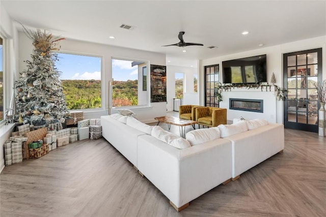 living area featuring recessed lighting, visible vents, ceiling fan, and a glass covered fireplace