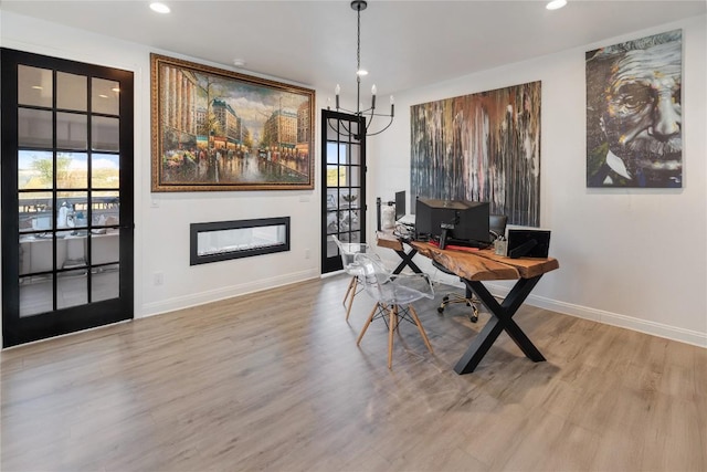 home office featuring a glass covered fireplace, recessed lighting, baseboards, and wood finished floors