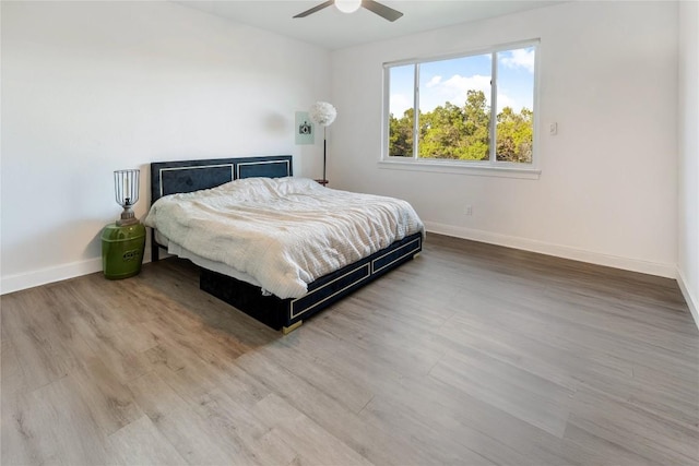 bedroom featuring ceiling fan, wood finished floors, and baseboards