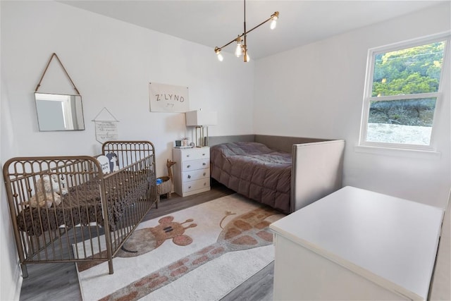 bedroom featuring wood finished floors and a notable chandelier